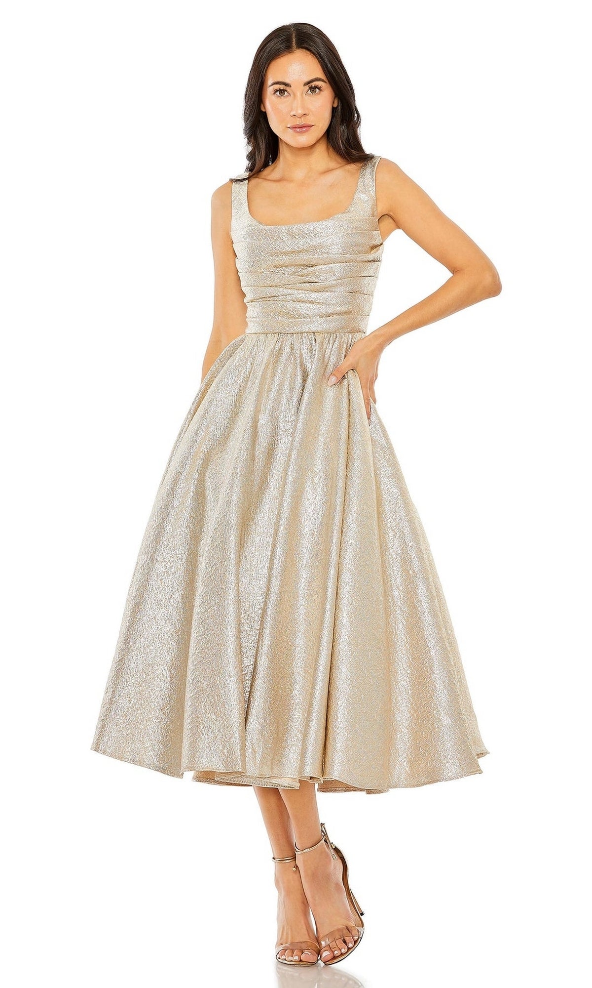 Woman in the Mac Duggal 68350 tea-length wedding-guest dress featuring a sleeveless fitted bodice, flared skirt in shimmery light gold, styled with metallic strappy heels.